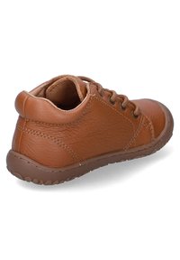 Brown leather sneaker with a textured surface, rounded toe, and lacing detail. Soft interior lining and flexible rubber sole.