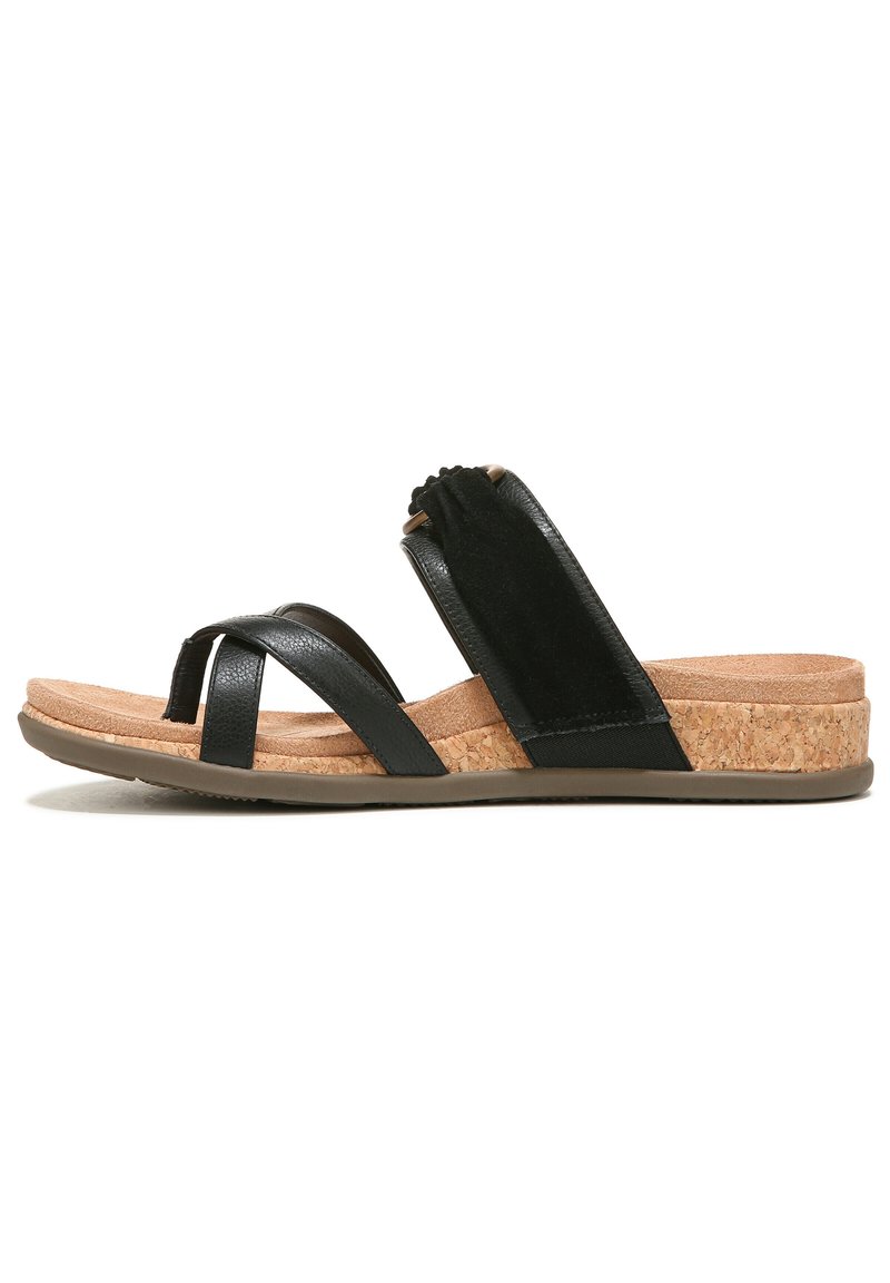 Black sandal featuring crisscross straps, a cork footbed, and a rubber outsole. Soft fabric accent on the instep for added comfort.