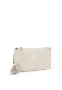 Gevoerde tas in lichtbeige stof met een gladde textuur. Bevat een rond logo en een bont pompon charme bevestigd met een ketting.