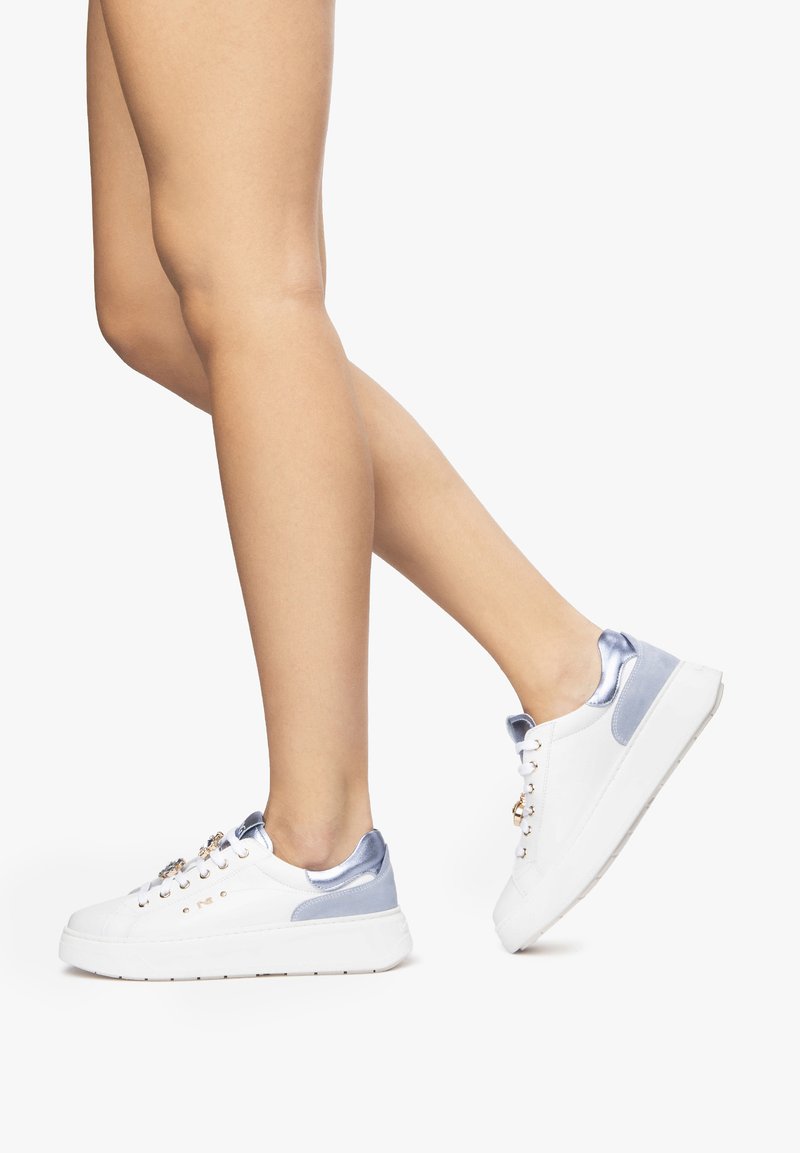 Zapatillas blancas con acabado liso, acentos azul claro en el talón y la lengüeta, con ojales dorados y una suela gruesa y texturizada.