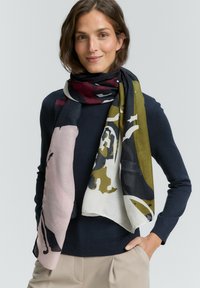 Écharpe multicolore avec un mélange de rose, vert et marine, ornée de motifs abstraits, fabriquée en tissu léger, drapée élégamment.