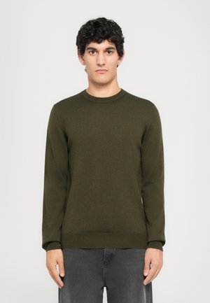 Dark green knit sweater with a round neck, long sleeves, and ribbed cuffs and hem. Worn with gray jeans, featuring a textured surface.