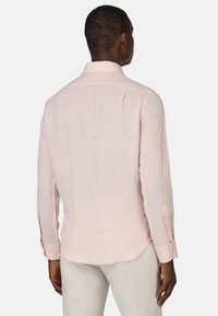 Camicia di lino rosa chiaro a maniche lunghe con colletto a bottone, dettaglio della piega posteriore e polsini con bottone; tessuto testurizzato con vestibilità casual.