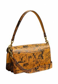 Sac à bandoulière en cuir marron clair avec inscriptions et gribouillis noirs style graffiti, comprenant "Forever" et des symboles abstraits, avec des ferrures dorées.