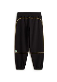Schwarze Jogginghose mit gelber Paspelierung, elastischem Bund und Bündchen. Auf der linken Beinvorderseite befindet sich ein grünes und weißes Logetikett. Glatte Textur.