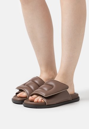 Brune polstrede slidssandaler med brede remme over foden og åben tå. Glat syntetisk materiale og lavprofil sort sål.