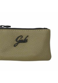 Trousse à crayons en cuir vert olive avec une surface texturée et une fermeture éclair noire. Présente un logo noir en relief à l'avant.