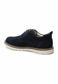 Zapato de piel ante azul marino con cordones y suela blanca, con costuras contrastantes y un interior acolchado para mayor comodidad.