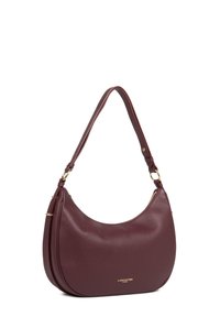 Borsa in pelle bordeaux con forma arrotondata, finitura texturizzata, dettagli in metallo dorato e una sola tracolla. Dettaglio del logo dorato visibile.
