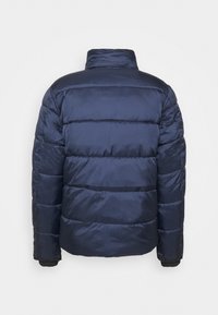 Marineblå pufferjakke med vandret syninger, høj krave og elastiske manchetter. Glat, blank tekstur med et let, isoleret design.