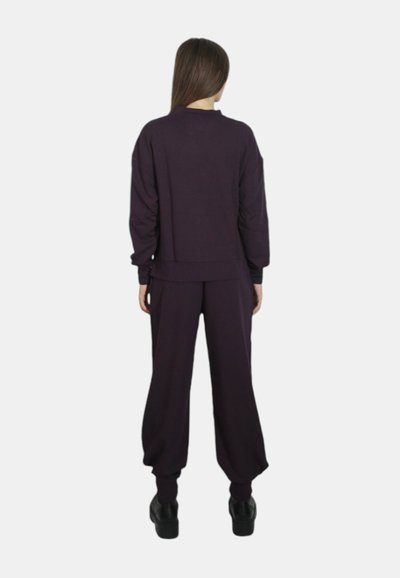 Set di abbigliamento casual viola composto da un top corto e pantaloni larghi, realizzato in un tessuto morbido con polsini a coste e un design semplice.