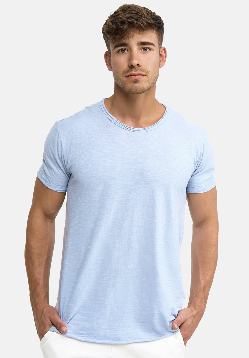 Lyseblå t-shirt med korte ærmer og rund hals, lavet af blødt, tekstureret stof, med en afslappet pasform og et subtilt meleret mønster.