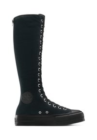 Botas altas de ante negro con ojales de metal, detalle con cremallera y un parche de marca circular en el lateral. Suela de goma gruesa y acabado texturizado.