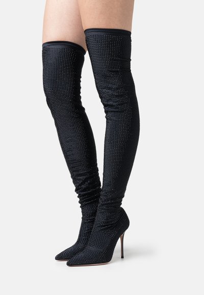 Black thigh-high boots with a pointed toe, featuring a textured fabric covered in small rhinestones. Slim-fit with a sleek silhouette.