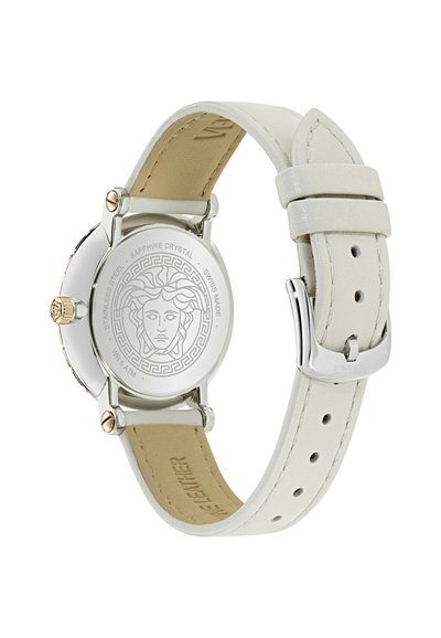 Sidabrinės spalvos laikrodžio galinė dalis su išgraviruota Medūzos galva ir užrašais, pritvirtinta prie balto odinio dirželio su sidabrine sagtimi.