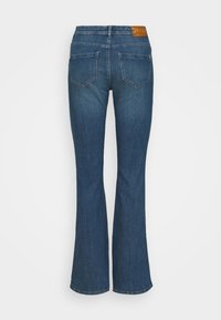 Mörkblå utsvängda jeans med hög midja, med en slät yta, två bakfickor och en brun läderetikett i midjan.