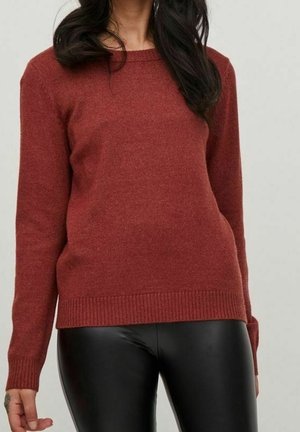 Maglione rosso lavorato a maglia con scollatura rotonda e polsini a coste, abbinato a leggings neri. Tessuto morbido, design aderente, maniche di lunghezza media.
