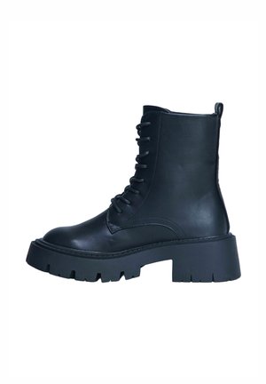 Botte de combat noire en cuir avec lacets, semelle épaisse à crampons et boucle de maintien à l'arrière, vue de profil sur fond blanc.