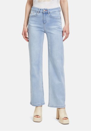 Hellblaue weit geschnittene Jeans mit hoher Taille, ausgestattet mit fünf Taschen, Gürtelschlaufen und einem Reißverschluss mit einer einzelnen Knopfverschluss.
