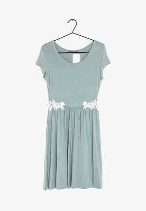 Robe bleu clair à manches courtes sur un cintre, avec un col arrondi et un détail en dentelle florale blanche à la taille, jupe froncée en dessous de la taille.