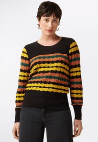 Geripptes Sweatshirt in Schwarz mit wellenförmigen Streifen in Gelb, Orange, Grün und Braun. Lange Ärmel mit engen Bündchen. Strukturiertes Gewebedetail.
