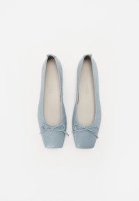 Ballerines bleu clair avec un design matelassé, un bout carré et un accent de nœud à l'avant. Fabriquées en matériau lisse avec un intérieur doux.