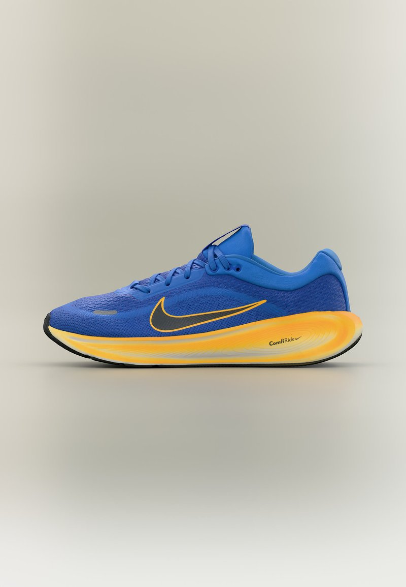 Chaussure de course Nike bleue avec semelle coussinée jaune et orange, swoosh Nike noir, et logo "ComfiRide" sur le côté.