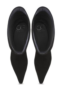 Black suede pointed-toe heels with a smooth inner lining and embossed logo. The design features a sleek and streamlined shape.