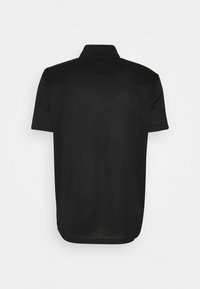 Polo noir à manches courtes vu de dos, avec un col et un ourlet légèrement arrondi.