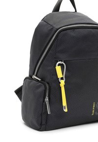 Svart texturerad ryggsäck med metalliska detaljer, utrustad med ett gult accentband och flera dragkedjefack. Kompakt, vinkelräta form.