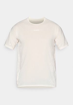 T-shirt de sport beige à manches courtes Salomon avec col rond et lignes graphiques blanches discrètes sur les côtés.