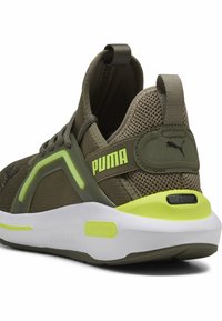 Grøn net sneakers med polstret krave, lyse gule accenter og en hvid sål. Har et logo på hælen og en struktureret design.
