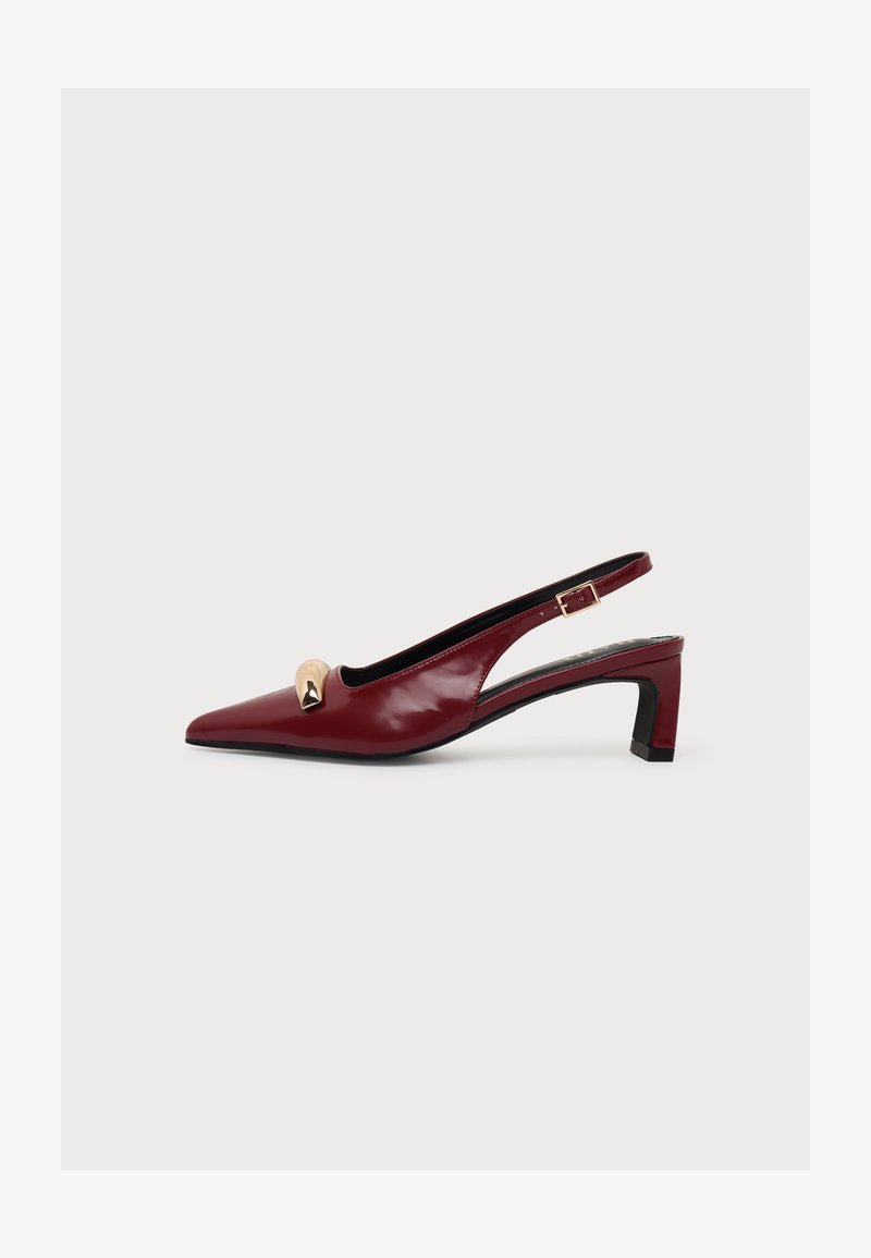 Escarpin slingback bordeaux en cuir verni à bout pointu, talon bloc bas, détail à clous dorés et bride réglable à boucle.