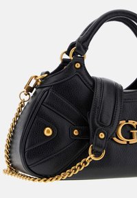 Sac à main en cuir noir texturé avec une chaîne en doré, des clous décoratifs et un embellissement de logo « G » entrelacé sur le devant.