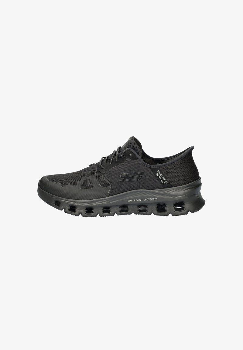 Zapatilla deportiva negra con parte superior de malla transpirable, diseño texturizado, cierre con cordones y suela acolchada con bolsas de aire visibles.