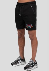 Sorte shorts med elastisk talje og snor, med et flerfarvet "WRONG FRIENDS" grafik på venstre ben og lynlås lommer.