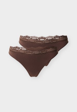 Due slip di cotone marroni con rifiniture in pizzo da donna, impilate su sfondo bianco.