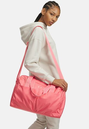 Roze reistas gemaakt van lichtgewicht materiaal, voorzien van dubbele handvatten, een lange verstelbare schouderriem en een zichtbaar merklogo aan de voorkant.