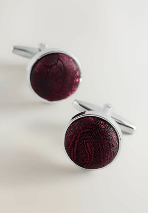 Round cufflinks featuring a textured burgundy fabric center within a polished silver setting, highlighting intricate patterns.