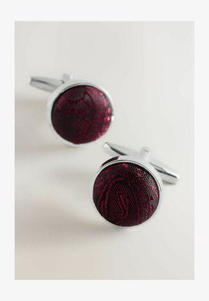 Round cufflinks featuring a textured burgundy fabric center within a polished silver setting, highlighting intricate patterns.