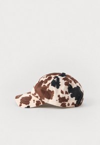 Brun og beige kuemønster baseballcaps med buet skjerm og teksturert stoff. Har en liten logo på siden.