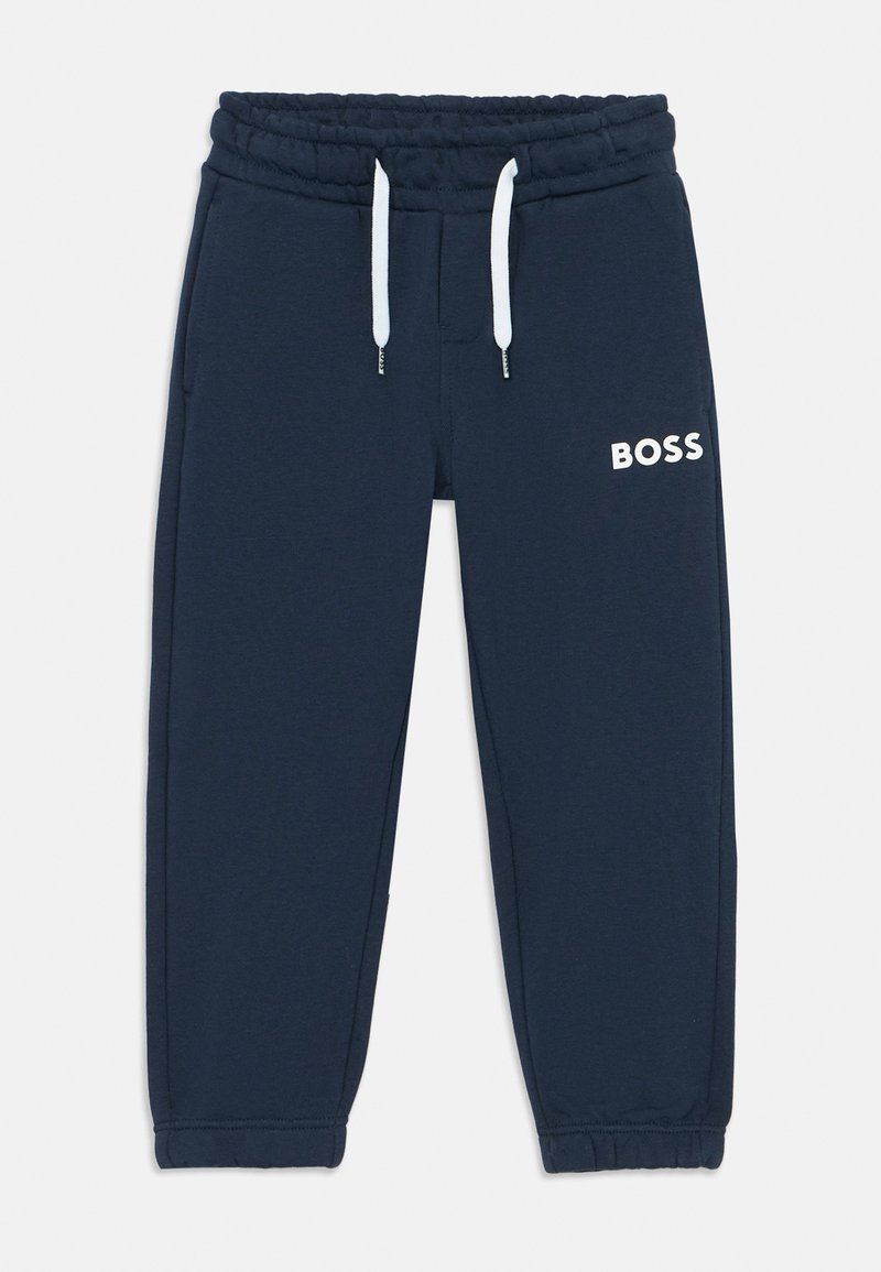 Pantalon de survêtement bleu marine avec une taille élastique, cordons blancs, et un logo "BOSS" blanc sur le côté gauche. Matière en coton doux.