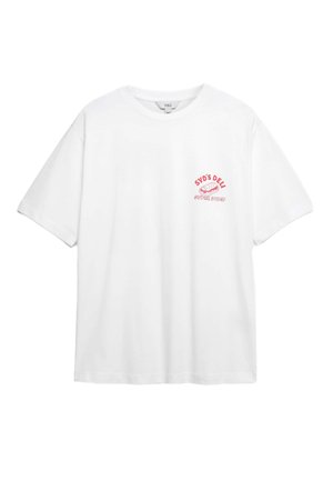 Camiseta de algodón blanca con mangas cortas y cuello redondo, que presenta un estampado gráfico en rosa en el lado izquierdo del pecho que dice "SYD'S DELI SUPER SUBS."