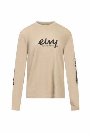 Beige longsleeve shirt van gestructureerde stof, met een ronde hals en zwart bedrukt logo op de voorkant en mouw.