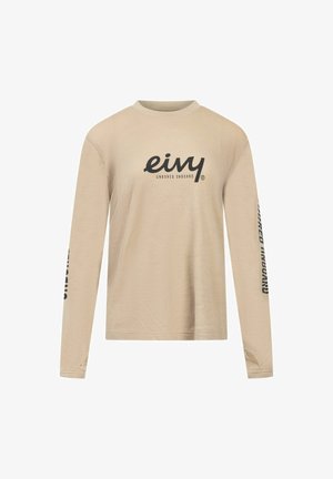 Beige longsleeve shirt van gestructureerde stof, met een ronde hals en zwart bedrukt logo op de voorkant en mouw.