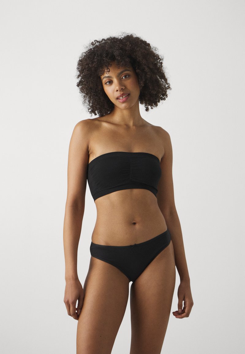 Svart bandeau-bikiniöverdel med samlad detalj och matchande låga bikiniunderdelar. Slät tygtextur, minimalistisk design.