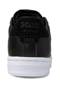 Black leather sneaker with a padded collar, white rubber sole, embossed logo and year "1966" in gold on back, featuring contrast stitching.
