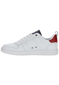Zapatilla blanca de cuero con suela de goma, punta redonda, lengua gris, acento en el talón rojo y cordones planos blancos. Presenta detalle de rayo lateral y perforaciones.