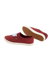 Pair of low-top red suede Vans sneakers with white laces and white rubber soles, one shoe showing waffle-patterned sole.