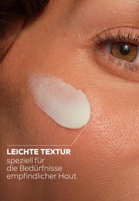 Light cream with a slight sheen applied to textured, tan skin, highlighting its moisture and suitability for sensitive skin.